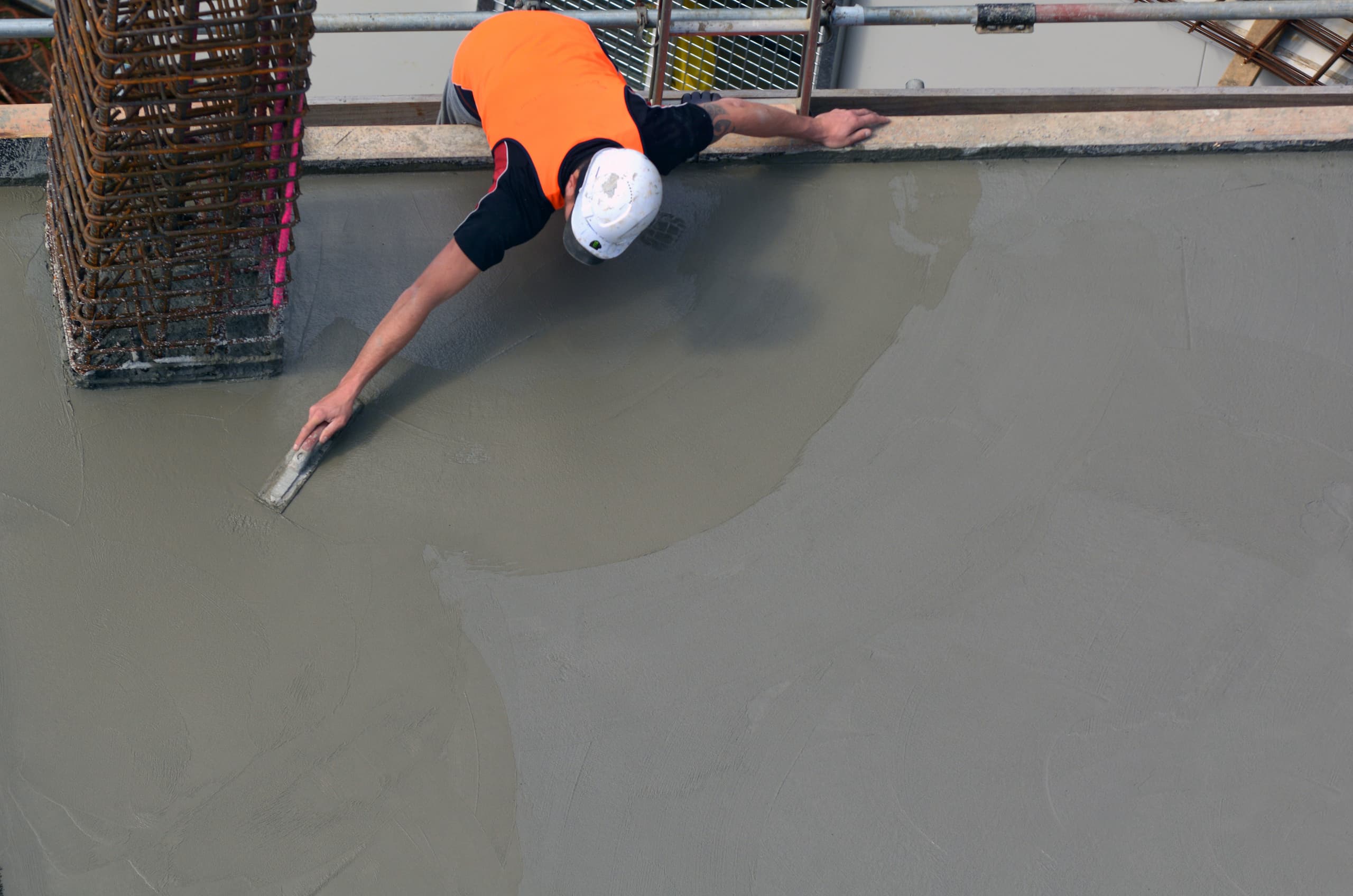 Construction worker smoothing a concrete mix