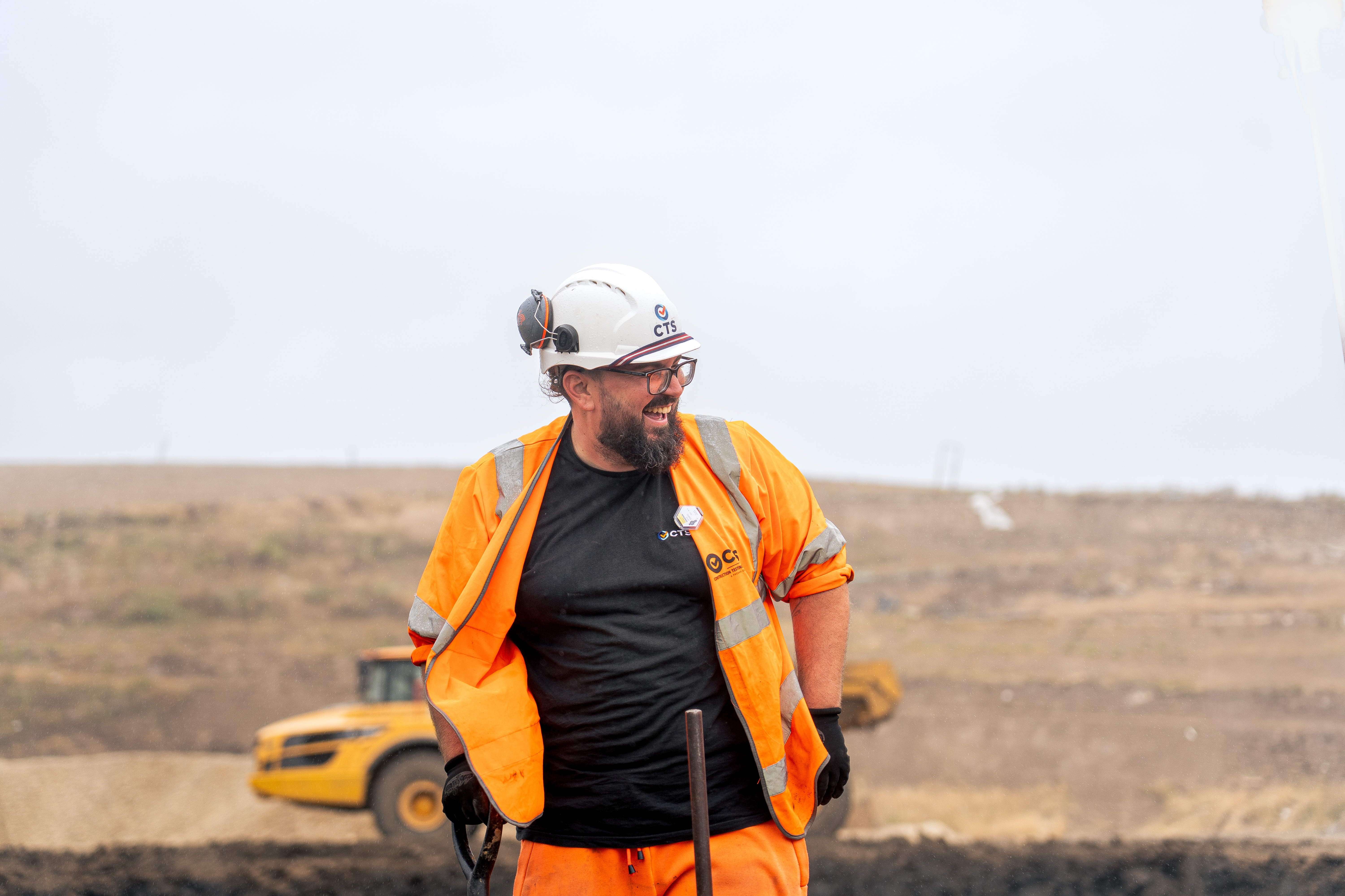 CTS worker on site smiling, wearing orange hi vis