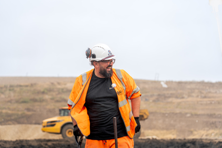 CTS worker on site smiling, wearing orange hi vis